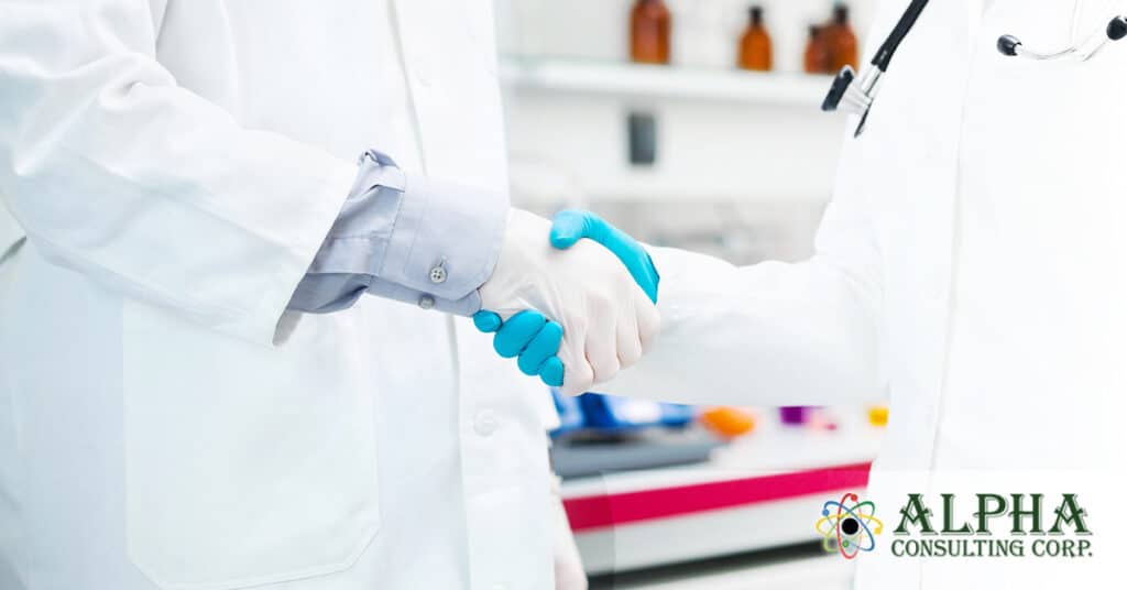 2 people shaking hands wearing rubber gloves