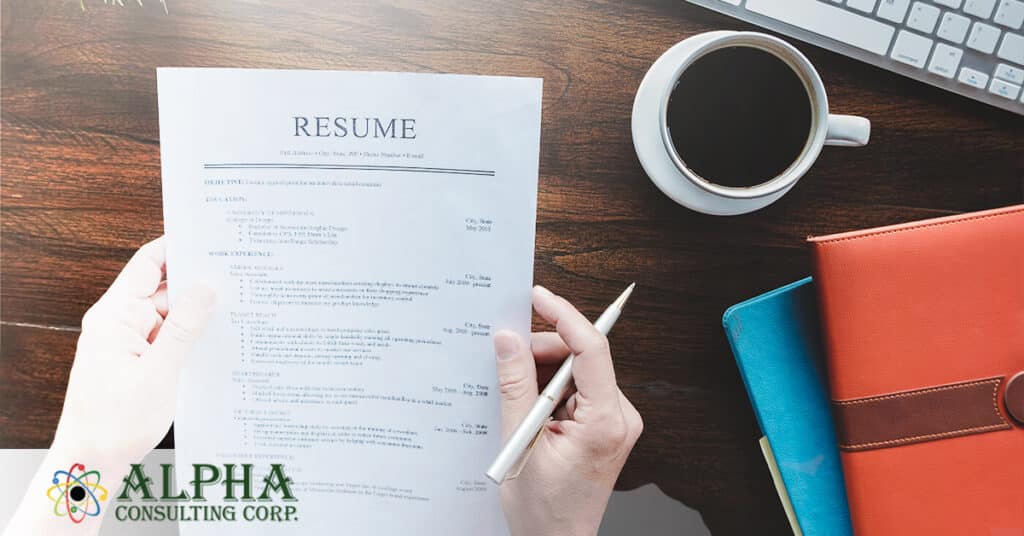 hands holding a resume at a desk