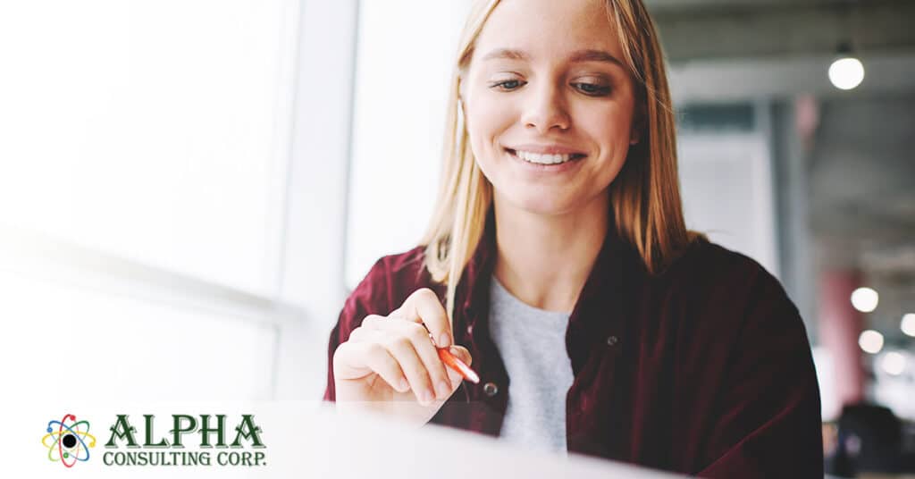 Grinning female job seeker, looking over her resume