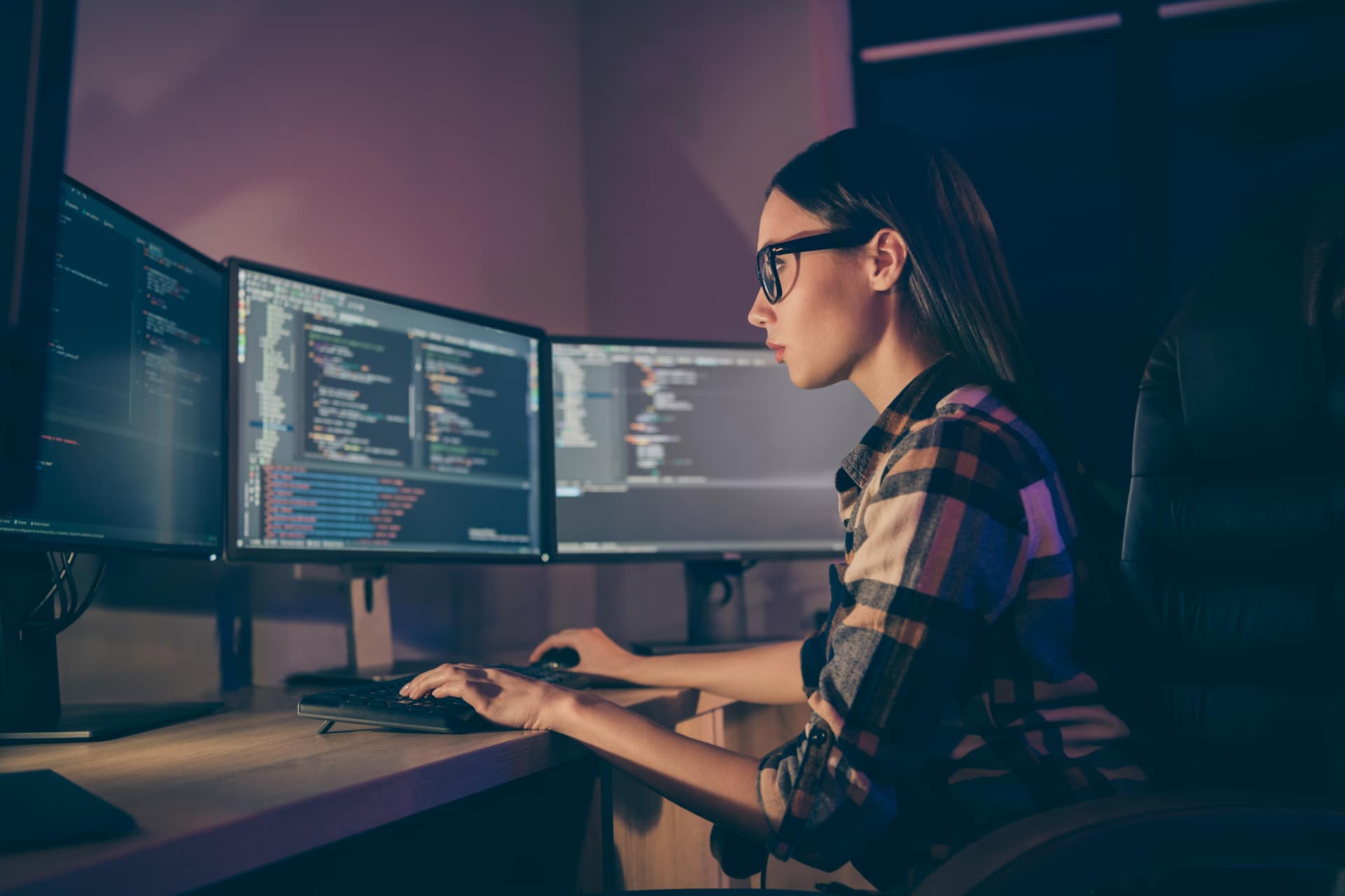 Women working at her desk with multiple monitors