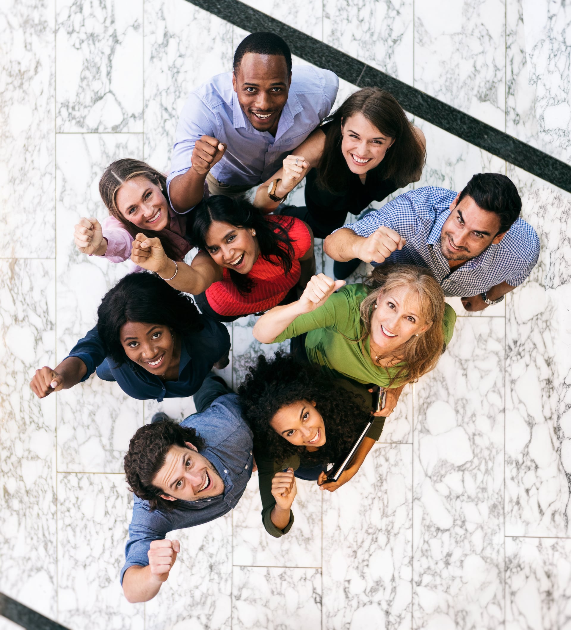 Group of students holding their fists up pictured from above