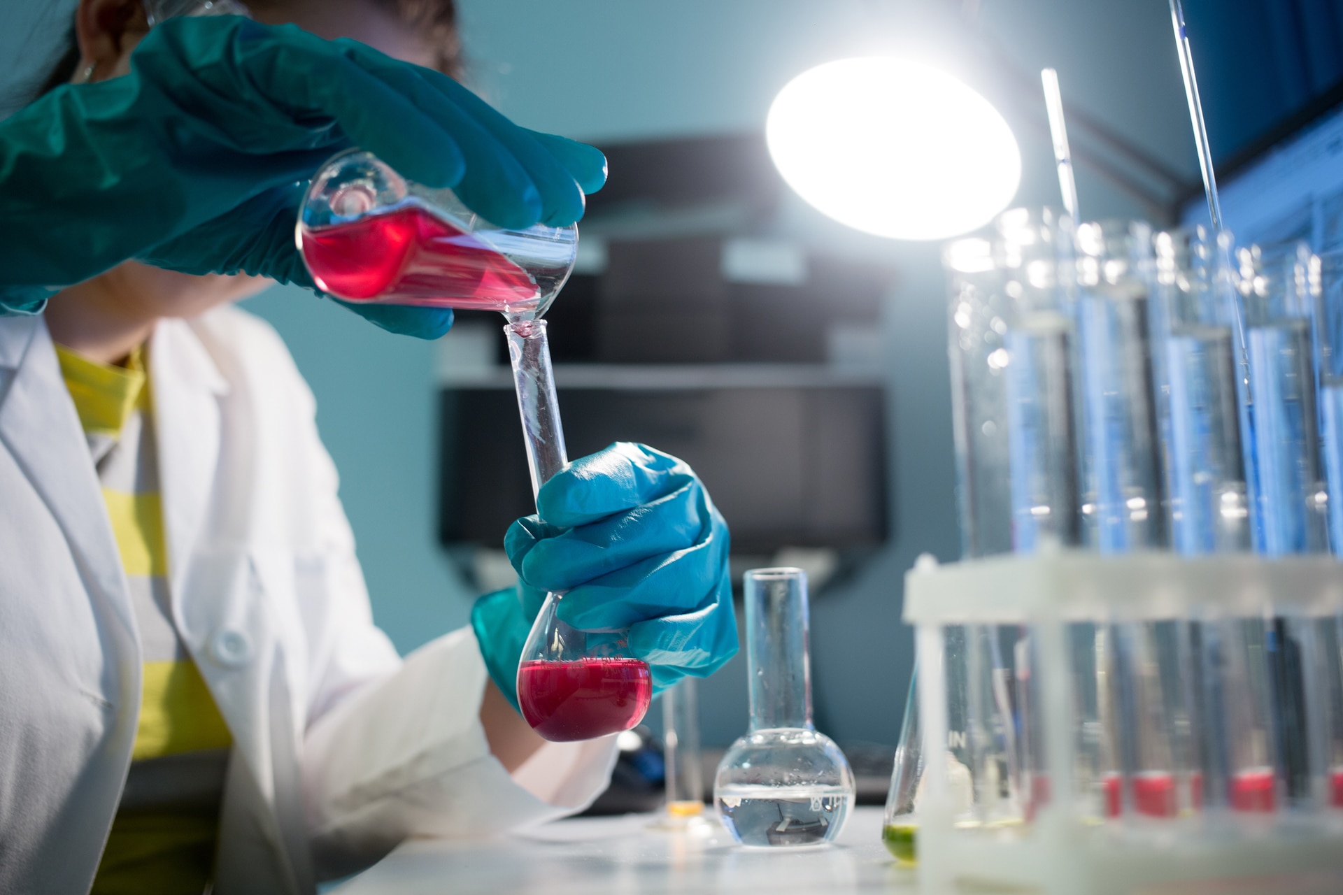 Lab technician pouring liquid in beaker